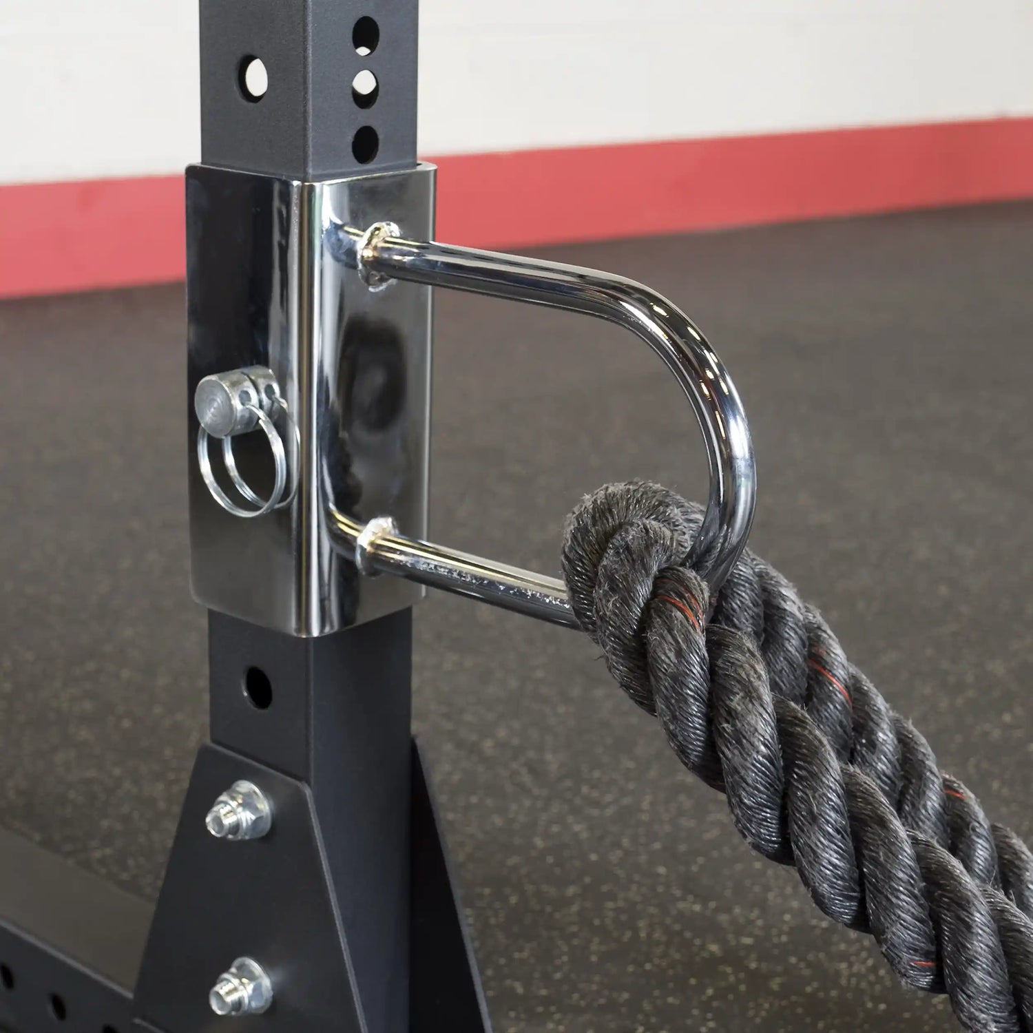 Close-up of the Body-Solid Pro ClubLine U-Link Attachment SPRUL, featuring a chrome attachment point and a thick rope secured to a black weight rack.
