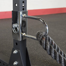 Close-up of the Body-Solid Pro ClubLine U-Link Attachment SPRUL, featuring a chrome attachment point and a thick rope secured to a black weight rack.