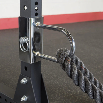 Close-up of the Body-Solid Pro ClubLine U-Link Attachment SPRUL, featuring a chrome attachment point and a thick rope secured to a black weight rack.