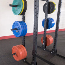 Image of a Body-Solid Pro ClubLine Weight Plate Horns Attachment SPRWPH with various colored weight plates organized on a vertical rack in a gym setting.