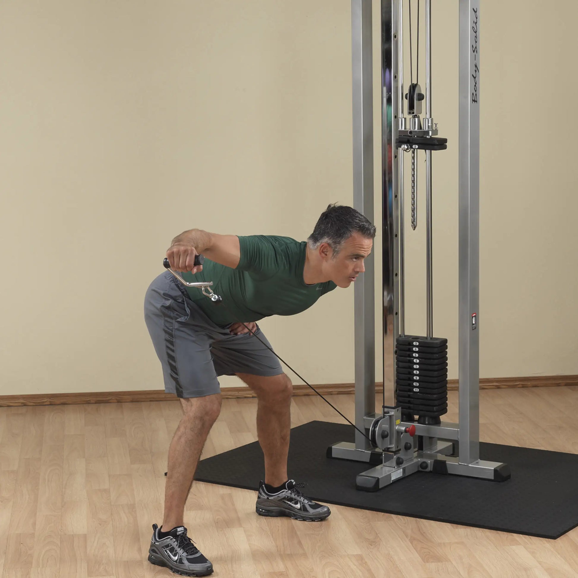 A man performing a cable exercise using the Body-Solid Pro Clubline Cable Crossover SCC1200G, demonstrating proper form with a focus on strength training.