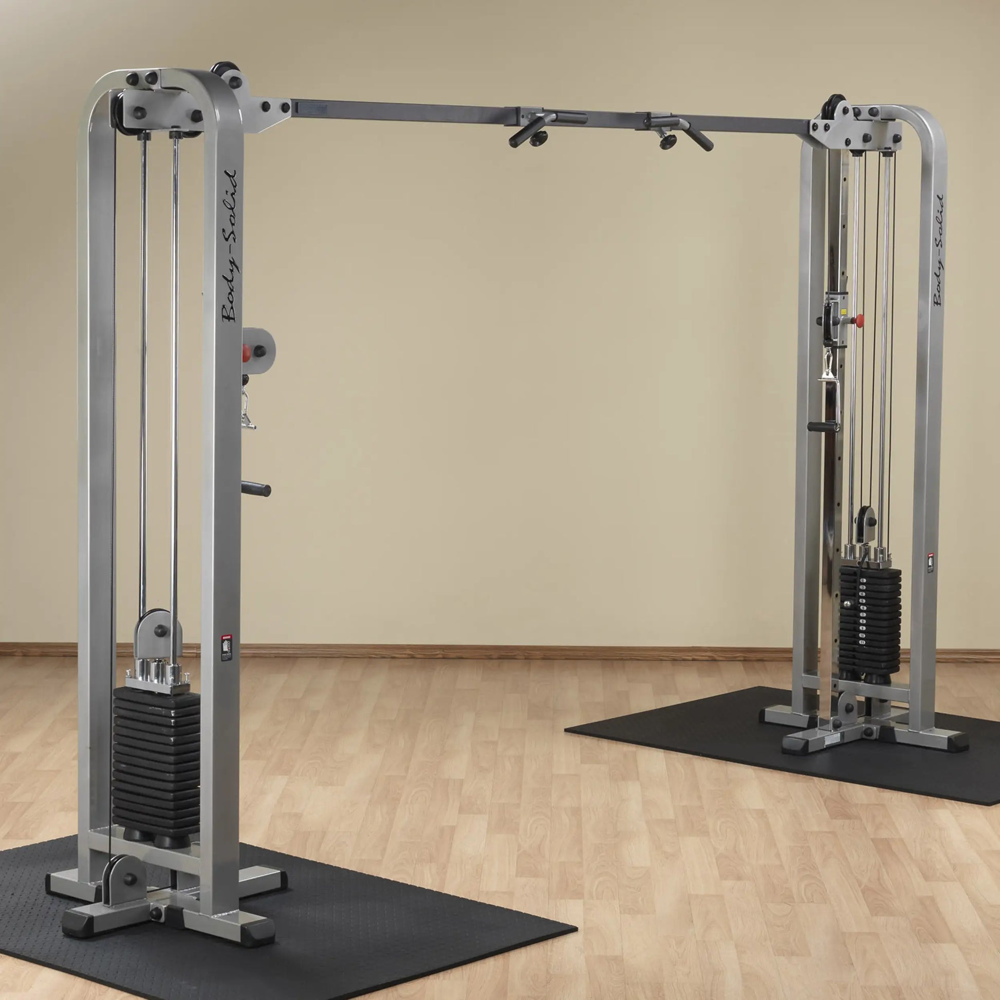 Body-Solid Pro Clubline Cable Crossover SCC1200G, featuring dual cable machines with adjustable pulleys and weight stacks on a wooden floor.