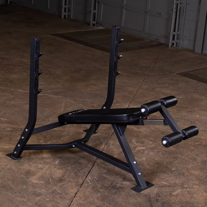 Body-Solid Pro Clubline Decline Olympic Bench SODB250 positioned on a concrete floor, featuring adjustable height barbell supports and padded leg rollers.