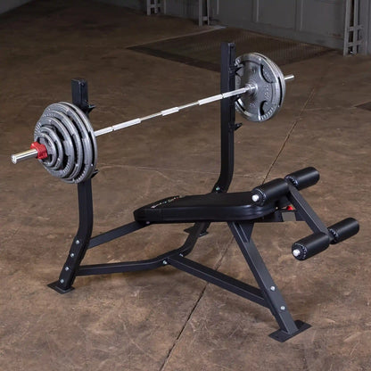 Body-Solid Pro Clubline Decline Olympic Bench SODB250 with a barbell and weight plates, set on a gym floor.