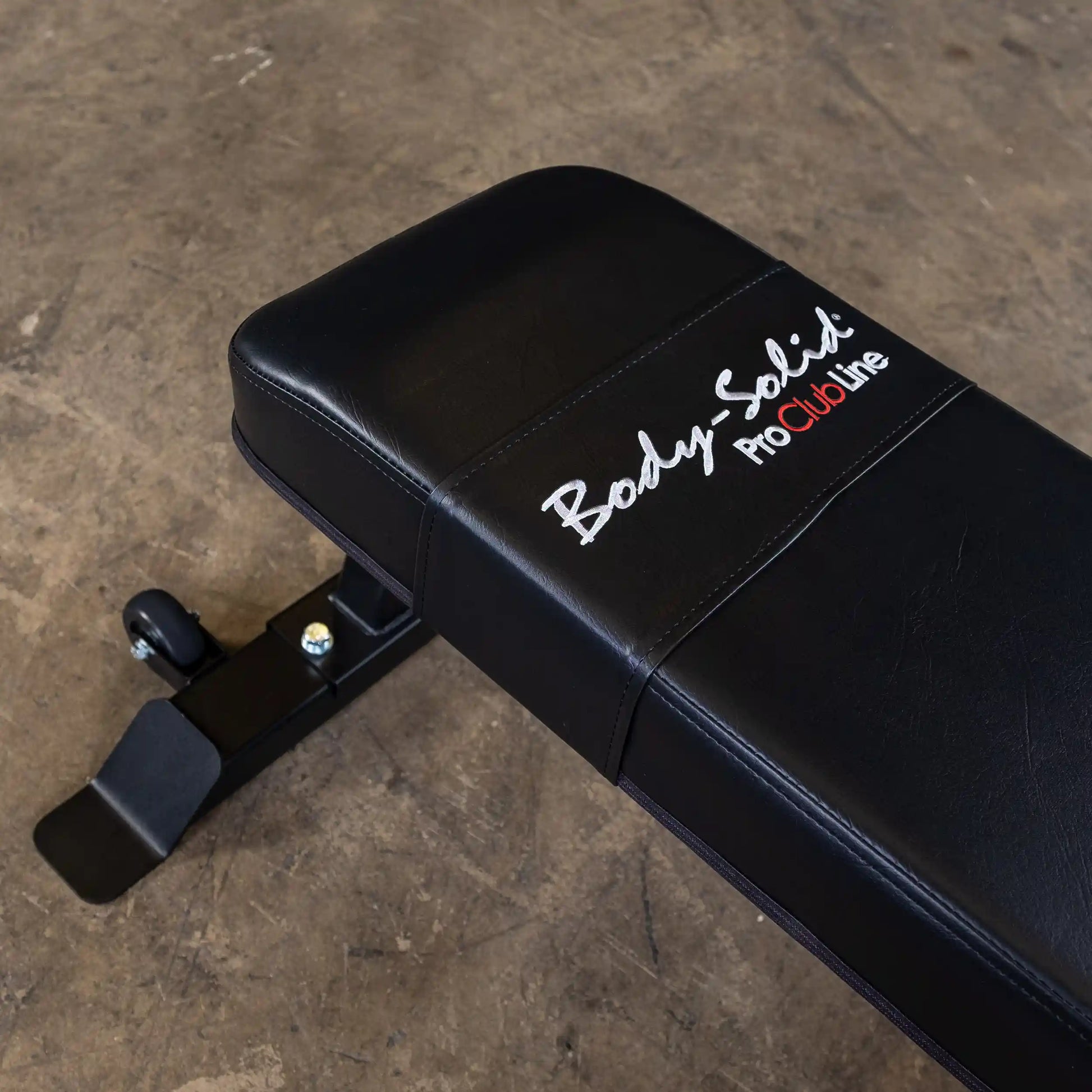 Close-up view of the Body-Solid Pro Clubline Flat Bench SFB125, featuring a black padded surface and sturdy metal base.