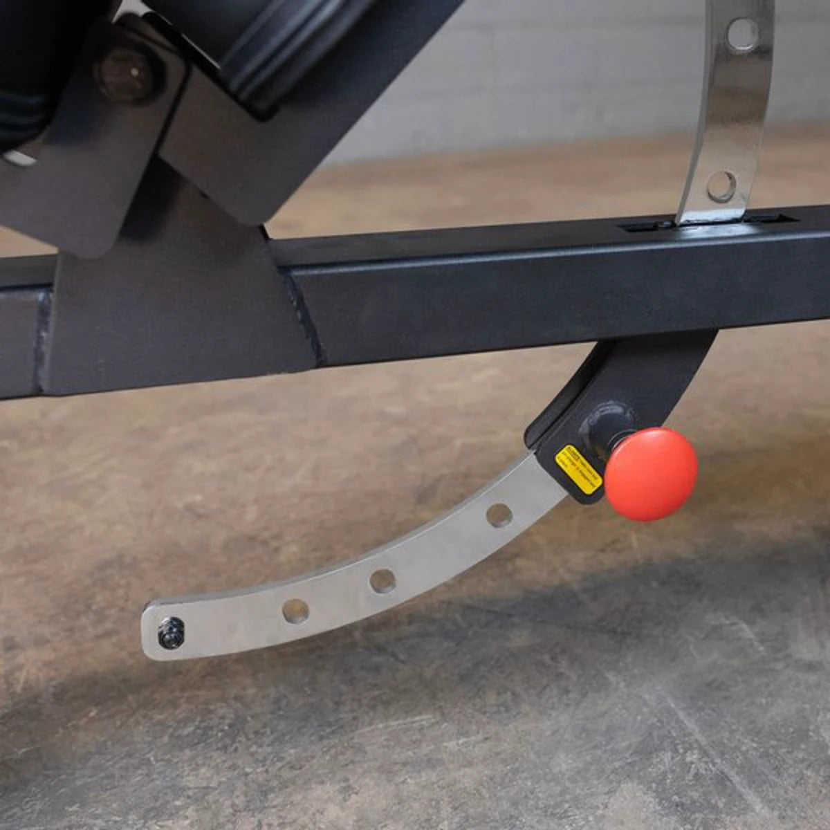 Close-up view of the adjustment mechanism on the Body-Solid Pro Clubline Flat/Incline Bench SFI20, showcasing the metal support and red adjustment button.