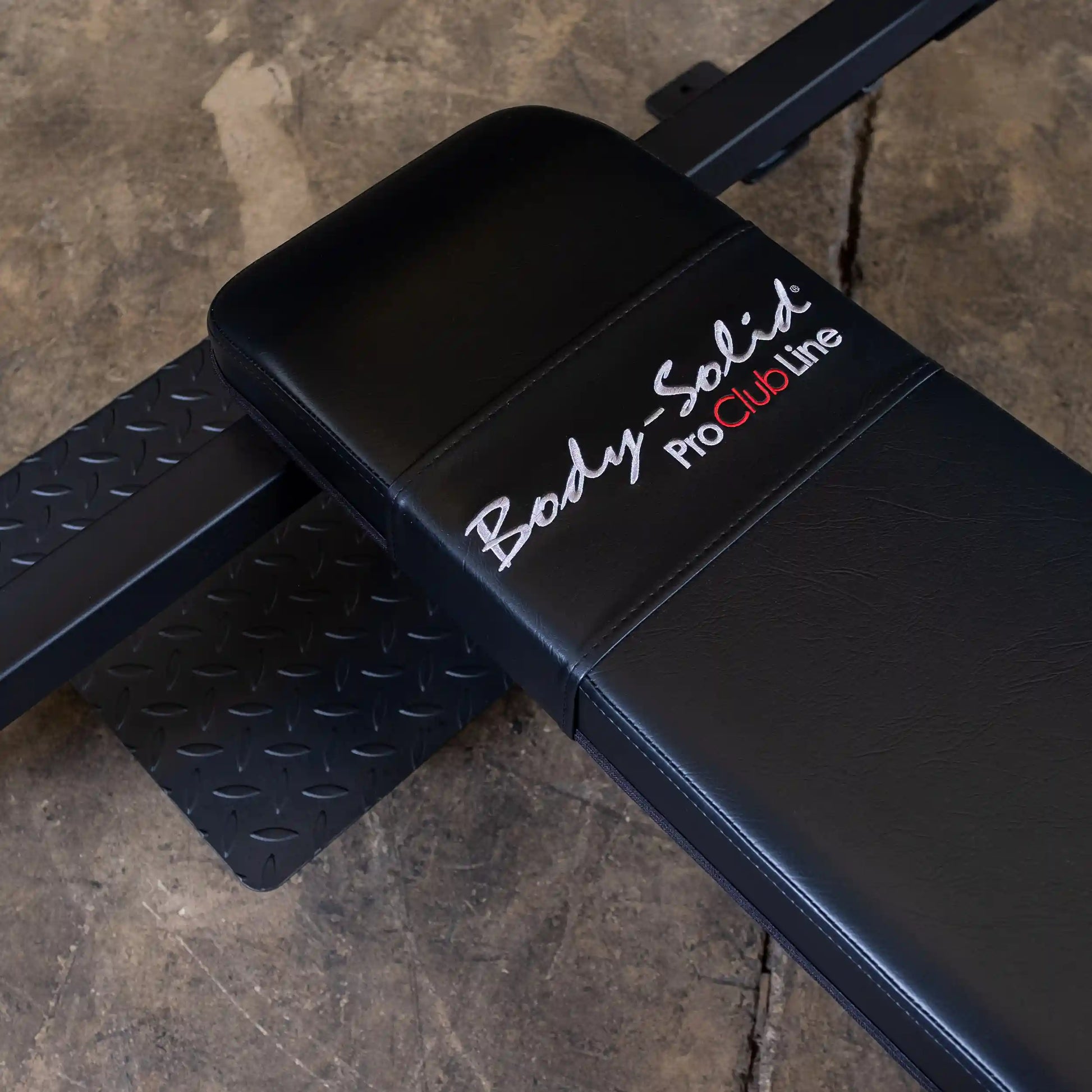 Close-up of the Body-Solid Pro Clubline Flat Olympic Bench SOFB250, featuring a black padded surface and sturdy metal frame.