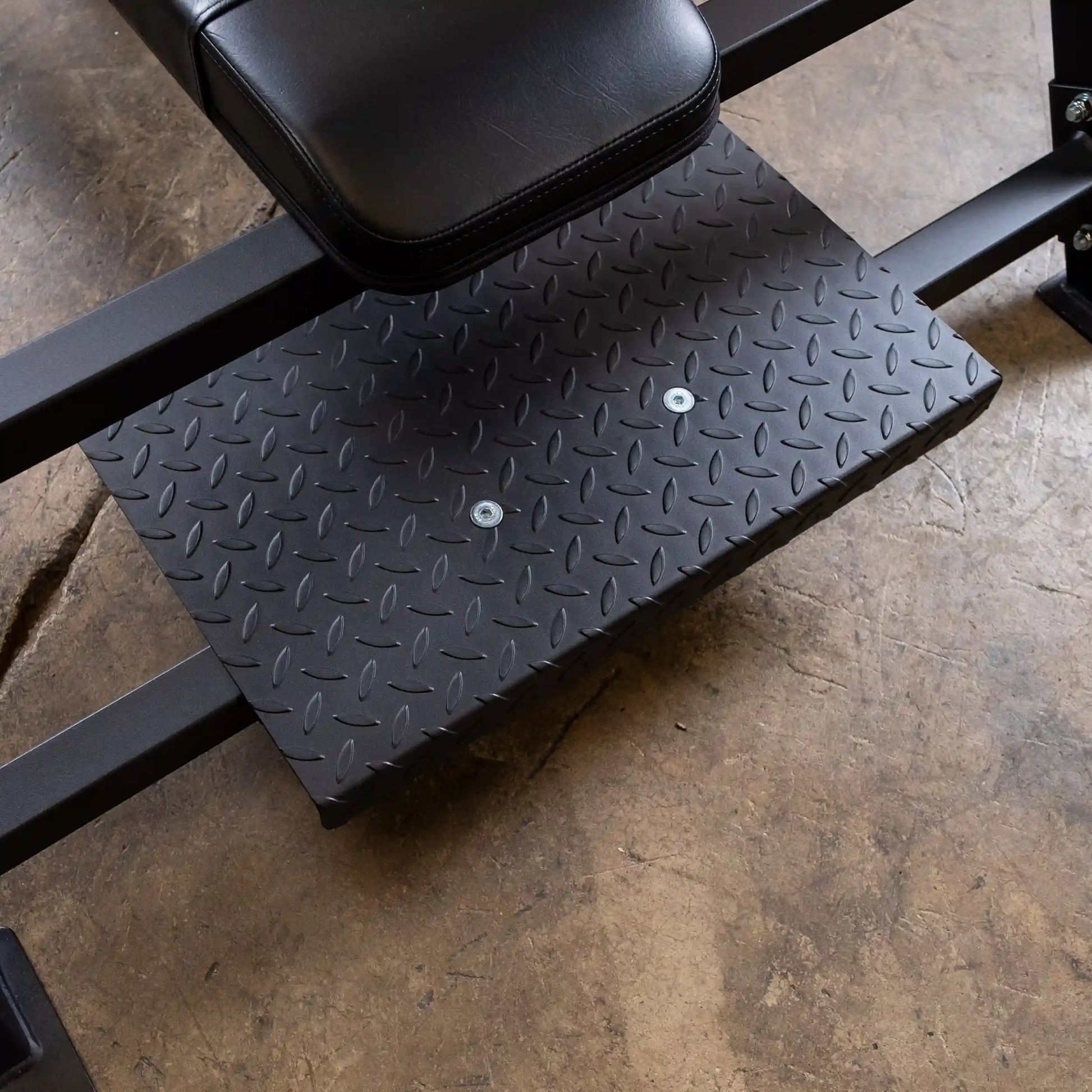 Close-up view of the Body-Solid Pro Clubline Flat Olympic Bench SOFB250, highlighting the textured black rubber footplate and sturdy frame on a concrete floor.