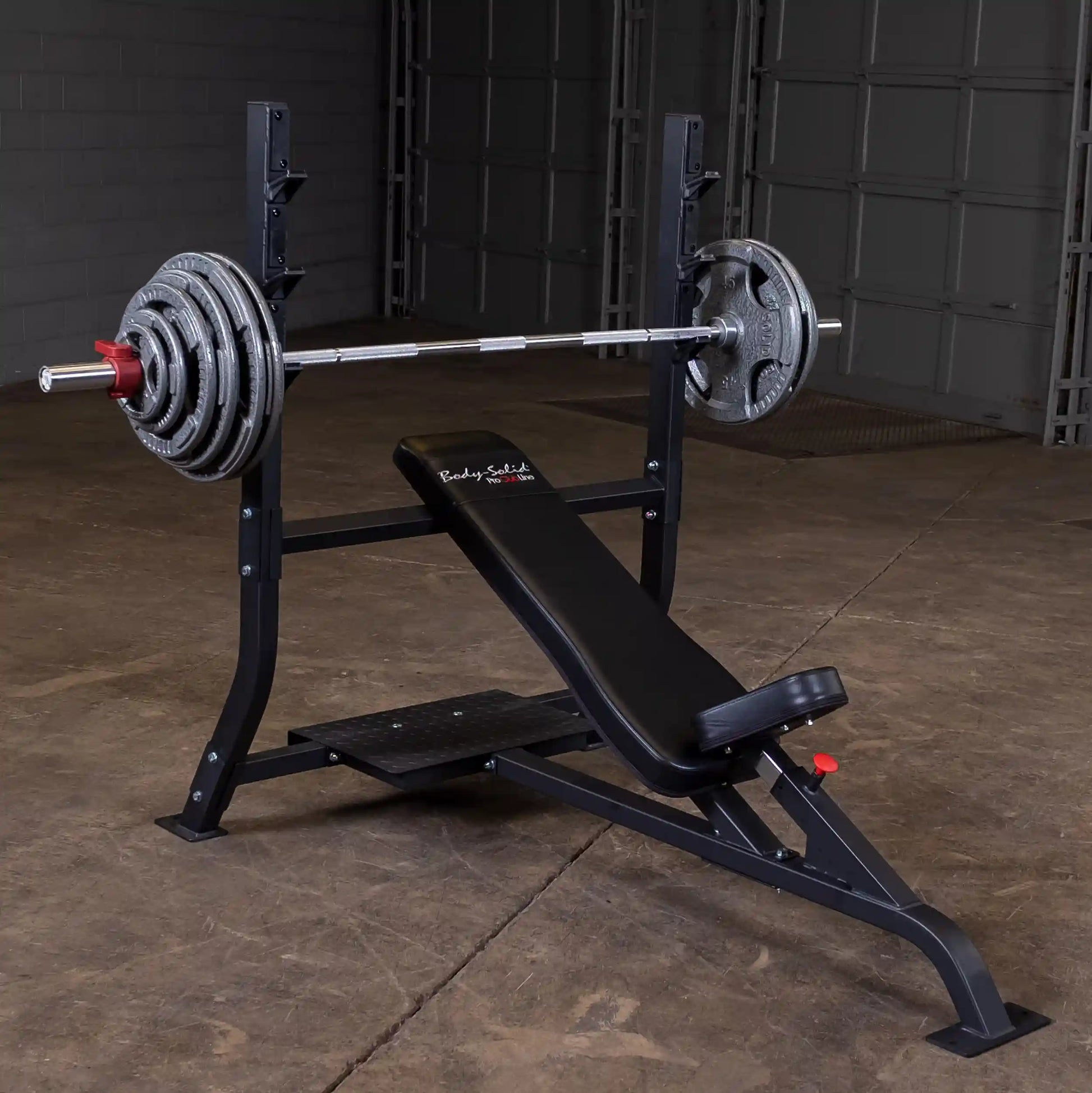 Body-Solid Pro Clubline Incline Olympic Bench SOIB250 with a barbell and weight plates, set up in a gym environment.