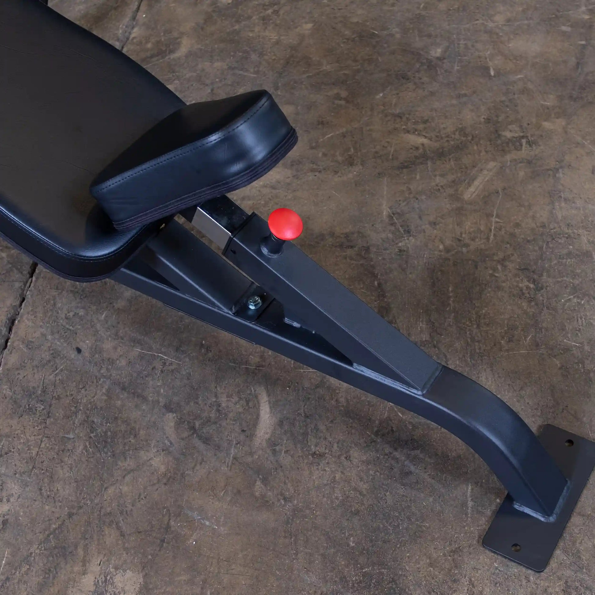 Close-up view of the Body-Solid Pro Clubline Incline Olympic Bench SOIB250 showing the adjustable seat and red adjustment knob on a textured surface.