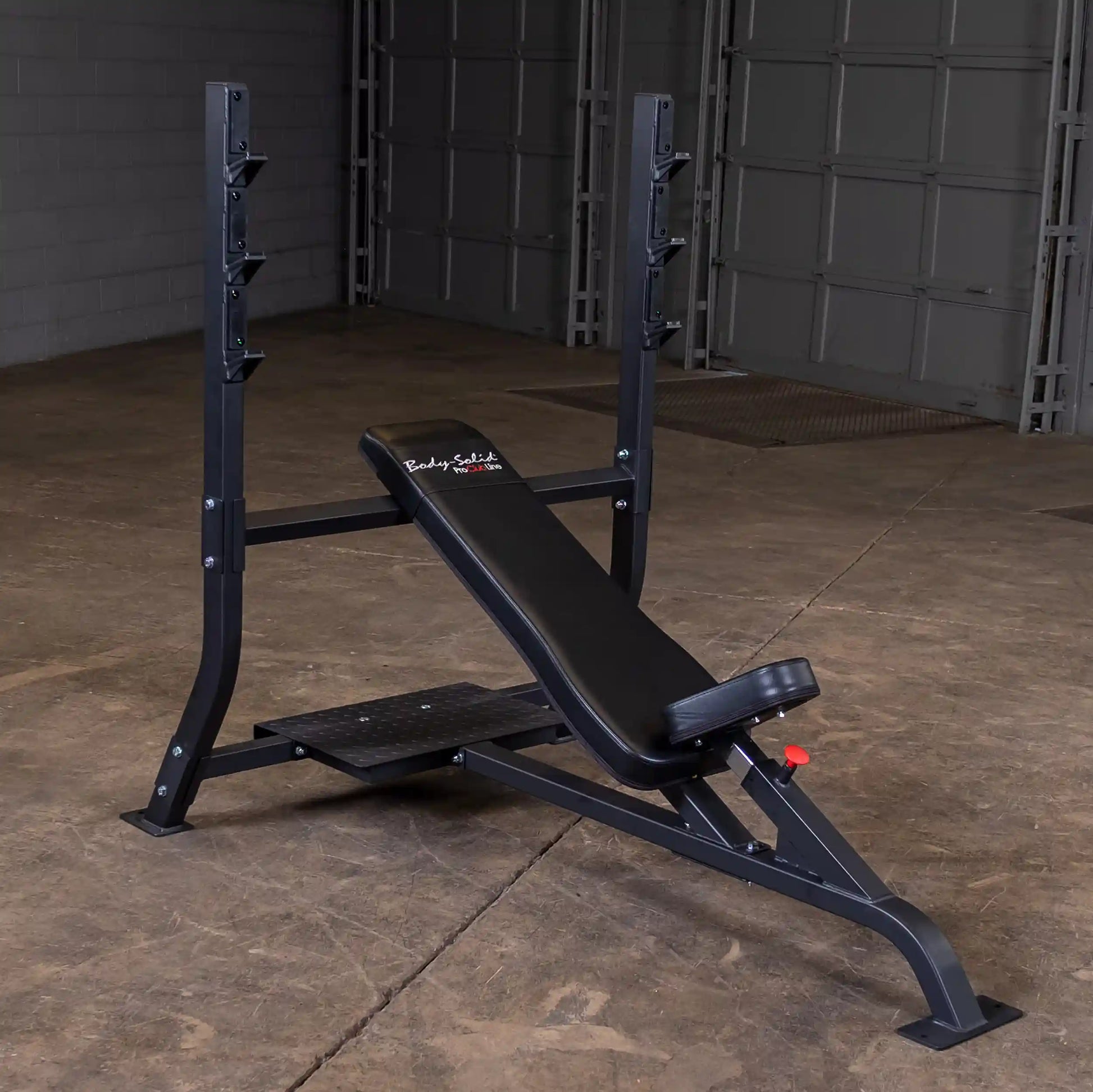 Body-Solid Pro Clubline Incline Olympic Bench SOIB250 positioned in a gym setting with a concrete floor and garage-style background.