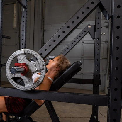 A person using the Body-Solid Pro Clubline Jammer Arms SPRJAM for a strength training exercise in a gym setting.