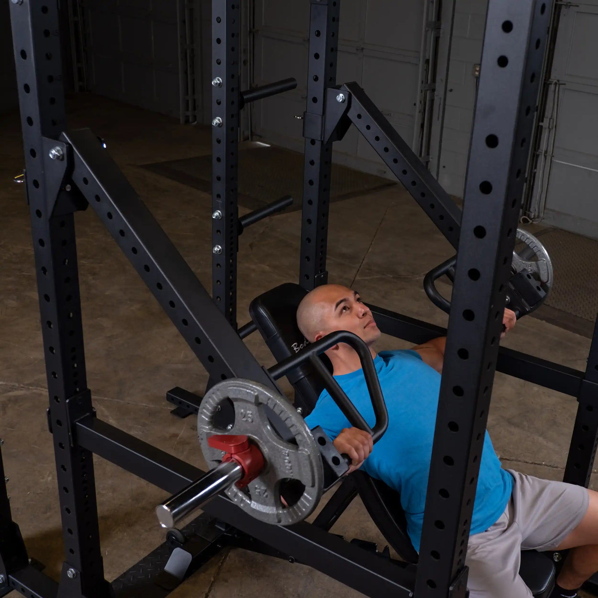 A person performing an exercise using the Body-Solid Pro Clubline Jammer Arms SPRJAM, seated in a gym setting.