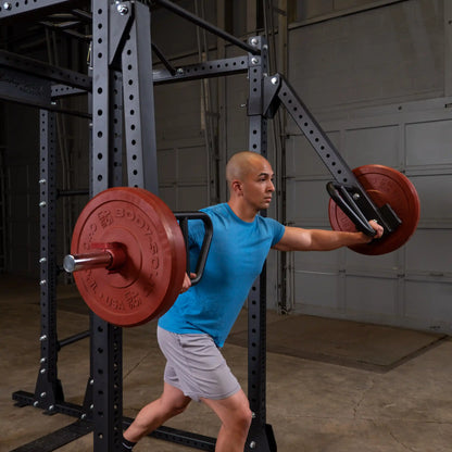 A person performing an exercise with the Body-Solid Pro Clubline Jammer Arms SPRJAM, showcasing a weightlifting setup in a gym environment.