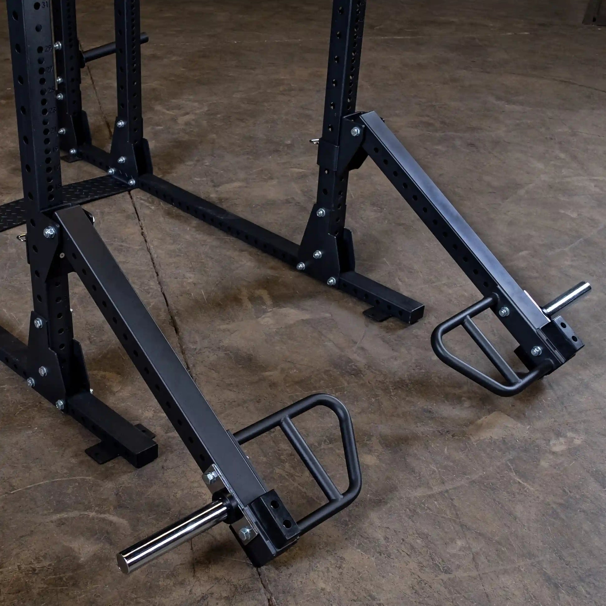 Body-Solid Pro Clubline Jammer Arms SPRJAM attached to a weightlifting rack, showcasing their sturdy design and functionality on a concrete floor.