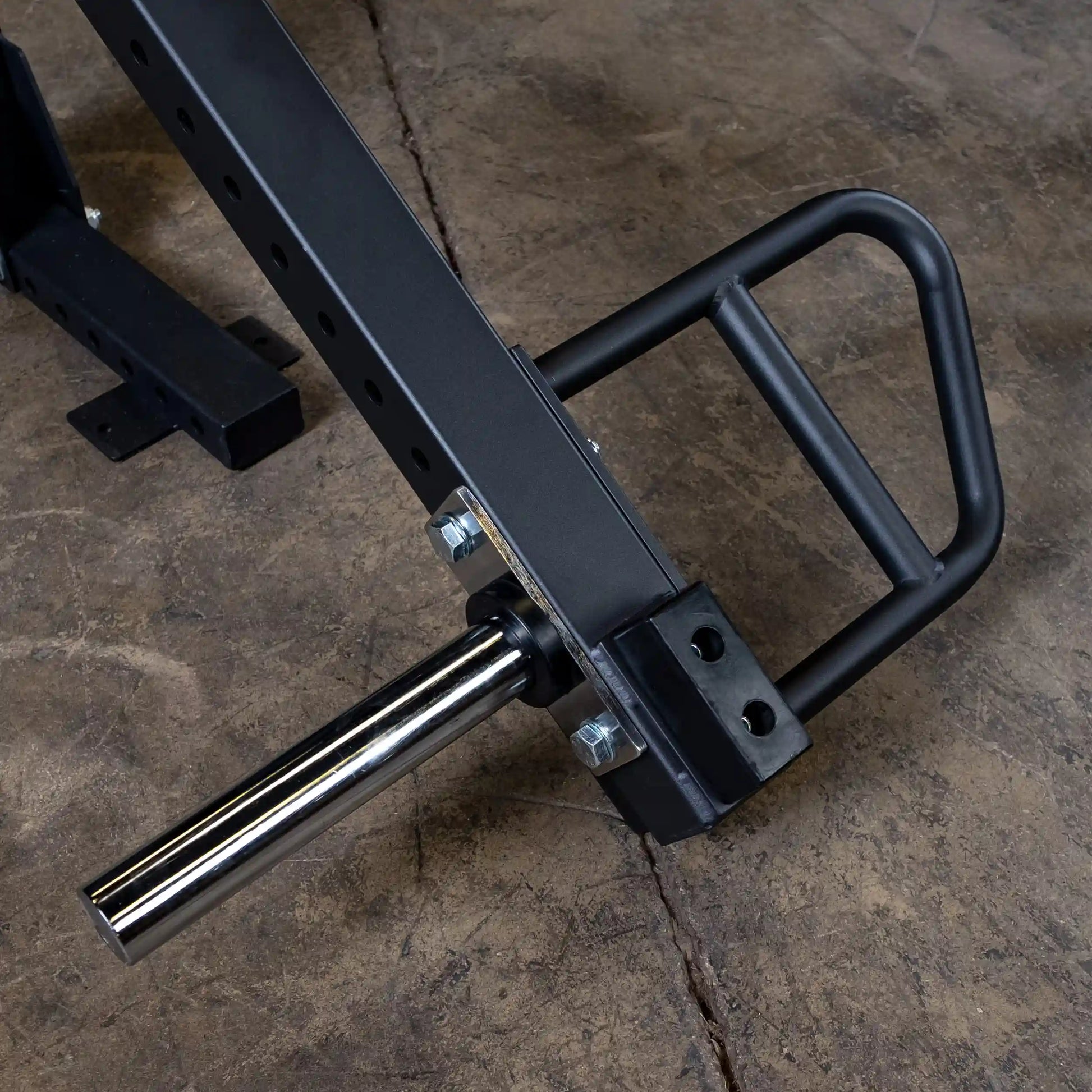 Close-up of the Body-Solid Pro Clubline Jammer Arms SPRJAM showing the sturdy black frame and chrome-plated bar attachment on a textured surface.