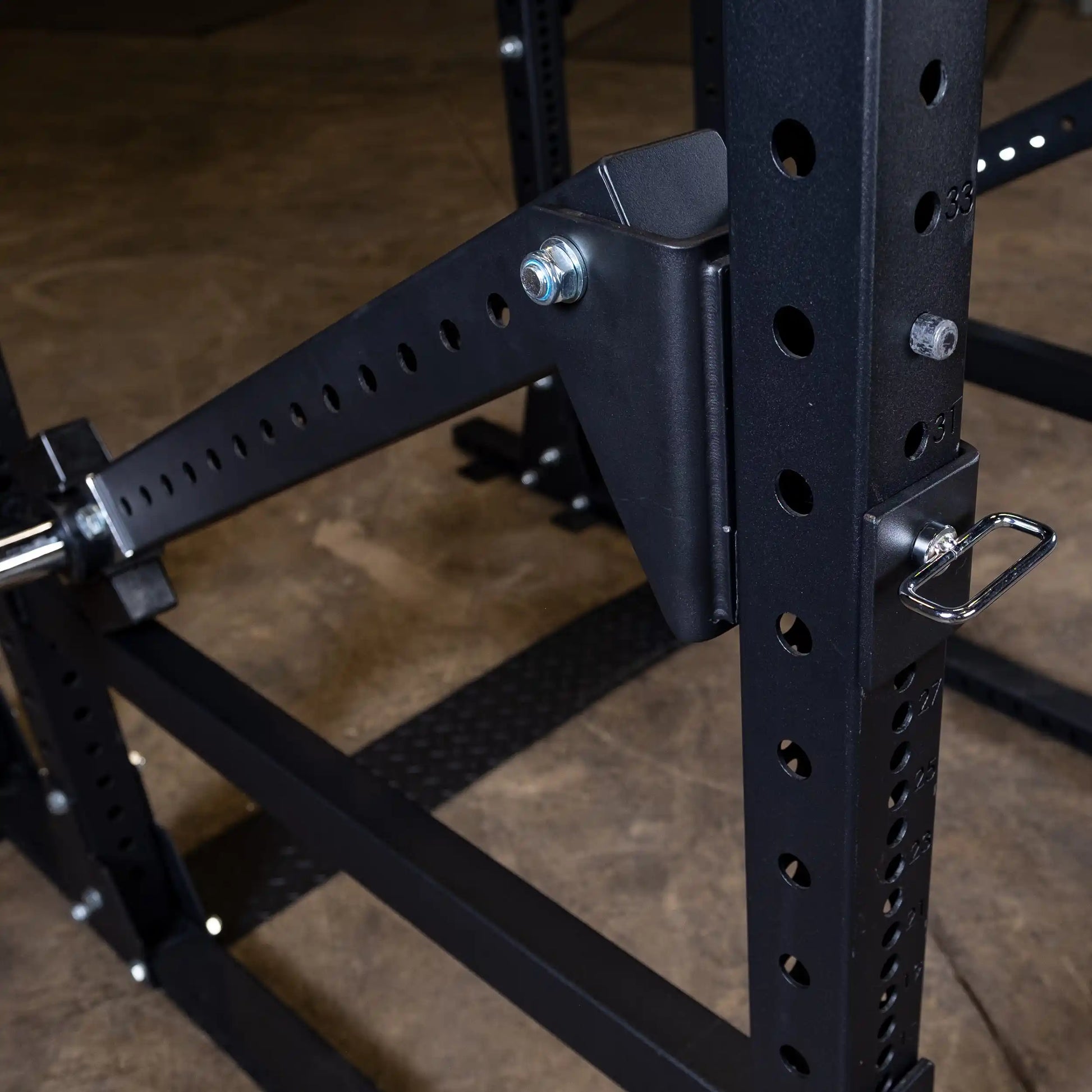 Close-up view of the Body-Solid Pro Clubline Jammer Arms SPRJAM, showcasing the adjustable arm attached to a sturdy gym rack with multiple holes for height adjustment.