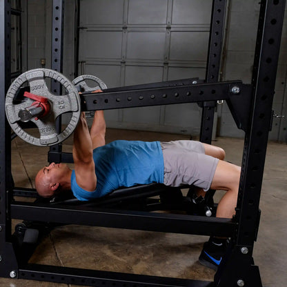 Man exercising on a bench press using Body-Solid Pro Clubline Jammer Arms SPRJAM in a gym setting.