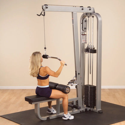 A woman using the Body-Solid Pro Clubline Lat & Mid Row Machine SLM300G2 in a gym setting, performing a rowing exercise.