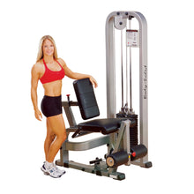 A fitness model demonstrating the Body-Solid Pro Clubline Leg Extension Machine SLE200G2, showcasing its design and features in a gym setting.
