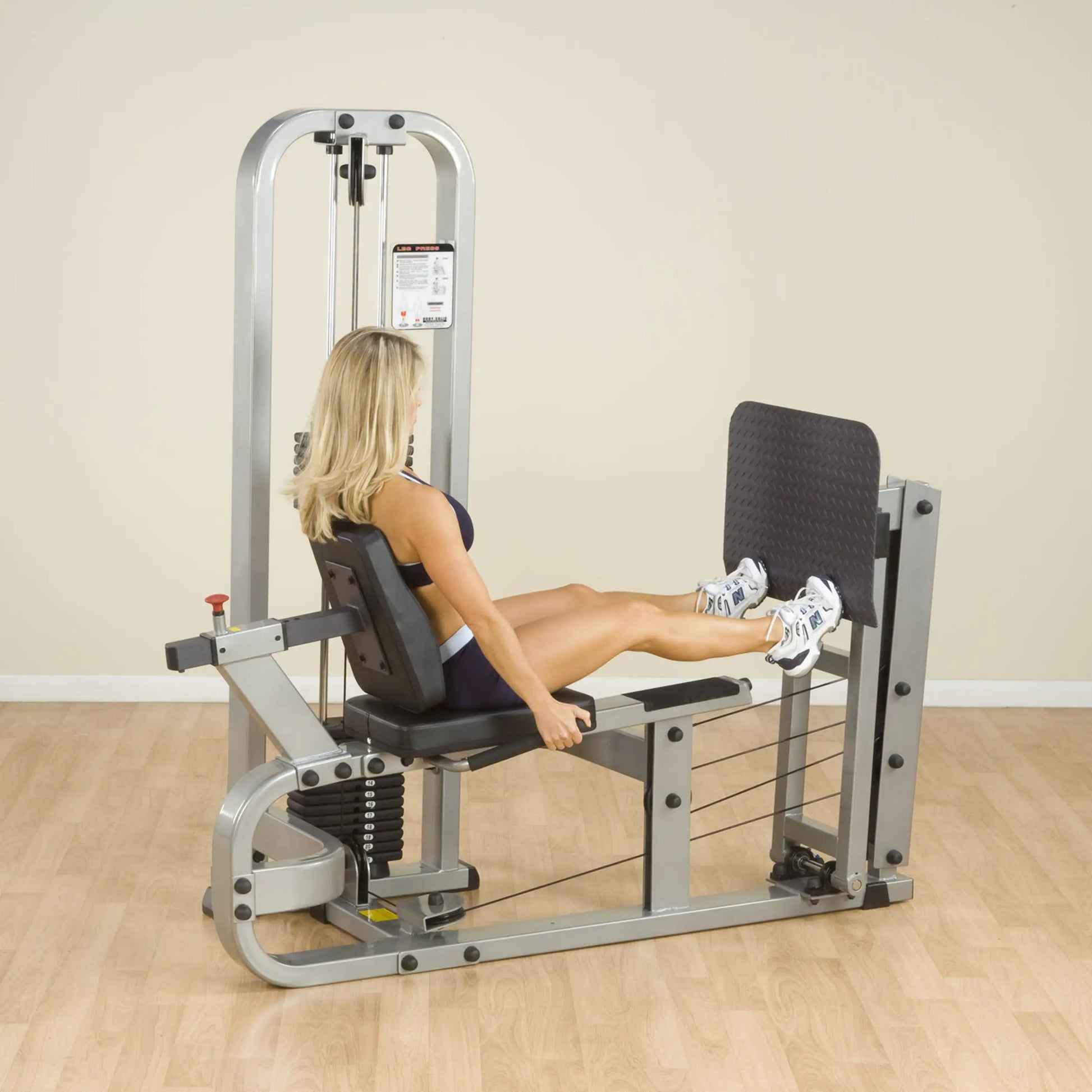 A woman using the Body-Solid Pro Clubline Leg Press Machine SLP500G2 in a gym setting, demonstrating leg press exercise.