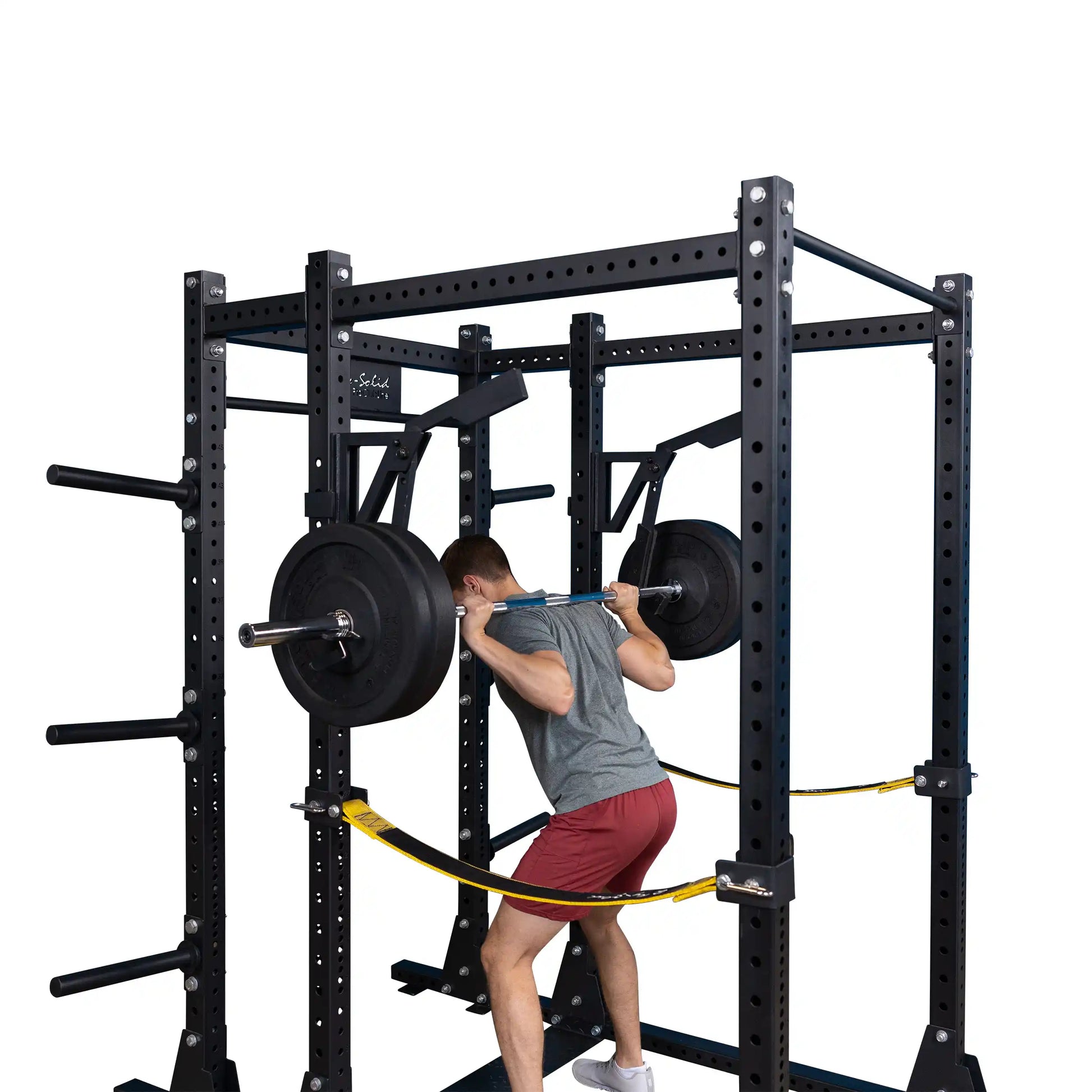 A person performing a squat with a barbell using the Body-Solid Pro Clubline Monolift Attachment SPRLFT in a power rack setup.