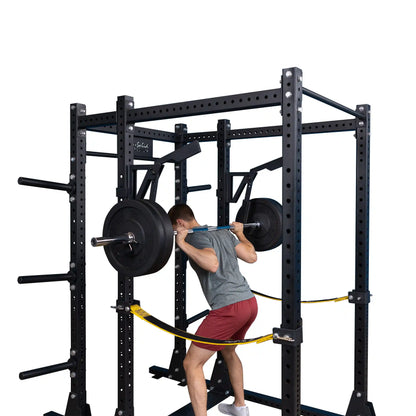 A person performing a squat with a barbell using the Body-Solid Pro Clubline Monolift Attachment SPRLFT in a power rack setup.