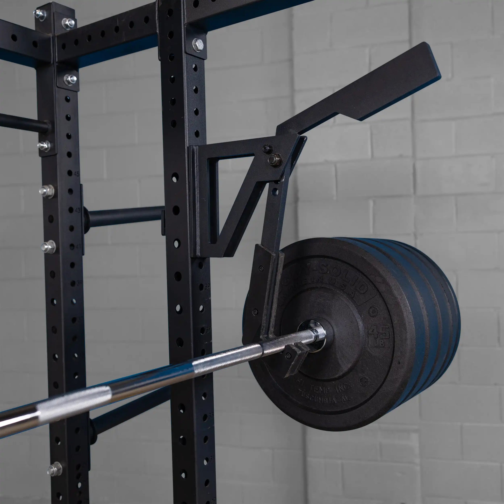 Close-up of the Body-Solid Pro Clubline Monolift Attachment SPRLFT mounted on a weight rack, featuring a barbell with weight plates.