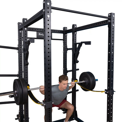 A person performing a squat with a barbell on a Body-Solid Pro Clubline Monolift Attachment SPRLFT, positioned within a sturdy squat rack.