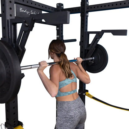 A person performing a squat with a barbell using the Body-Solid Pro Clubline Monolift Attachment SPRLFT, showcasing the equipment in a gym setting.