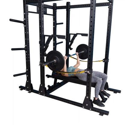A person performing a bench press with weights using the Body-Solid Pro Clubline Monolift Attachment SPRLFT in a squat rack.