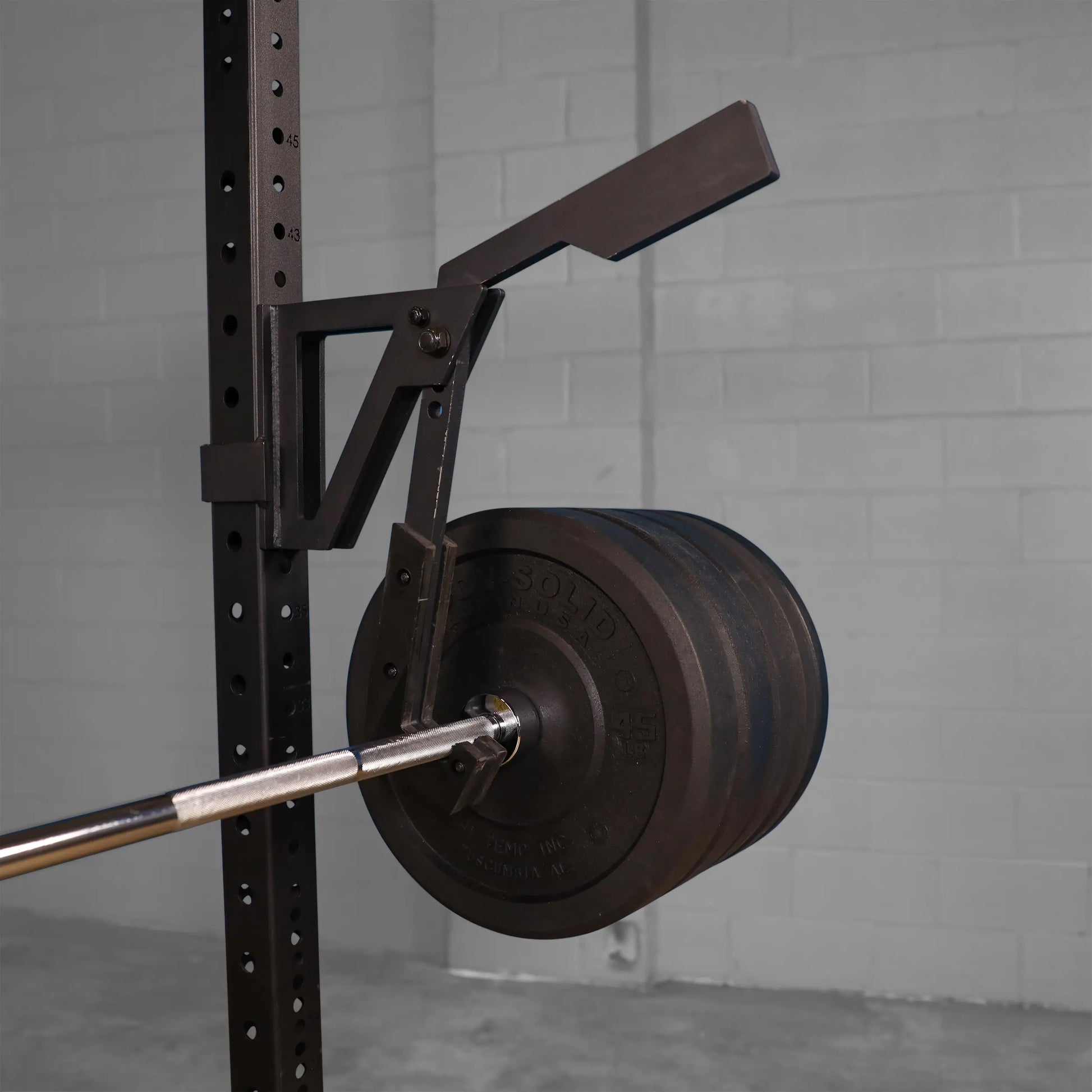 Image of a Body-Solid Pro Clubline Monolift Attachment SPRLFT mounted on a rack, featuring a barbell and weight plates visible in the foreground.