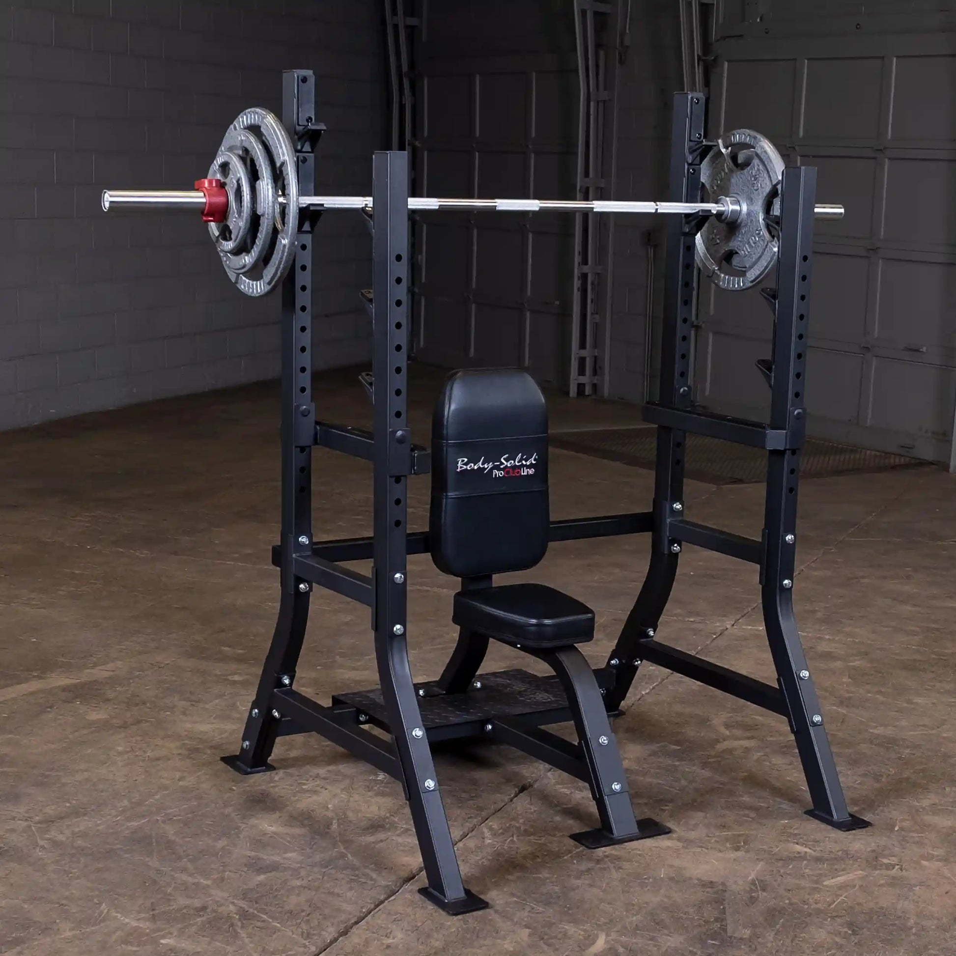 Body-Solid Pro Clubline Shoulder Olympic Bench SOSB250, featuring a sturdy frame with adjustable supports and a padded seat, displayed in a gym setting with weight plates on the barbell.