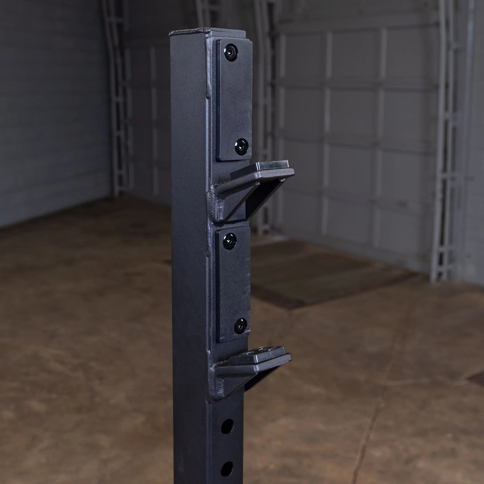 Close-up view of the Body-Solid Pro Clubline Shoulder Olympic Bench SOSB250 showing the vertical support with adjustment holes and safety clips.
