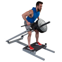 A person performing a bent-over row exercise using the Body-Solid Pro Clubline T-Bar Row Machine STBR500, with weights on the bar and wearing athletic clothing.
