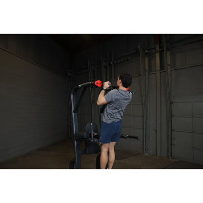Person using the Body-Solid Pro Clubline Vertical Knee Raise SVKR1000 in a gym setting, demonstrating an exercise.