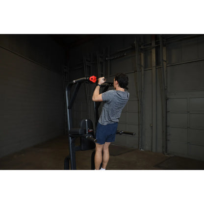 A person using the Body-Solid Pro Clubline Vertical Knee Raise SVKR1000 for an exercise in a gym setting.