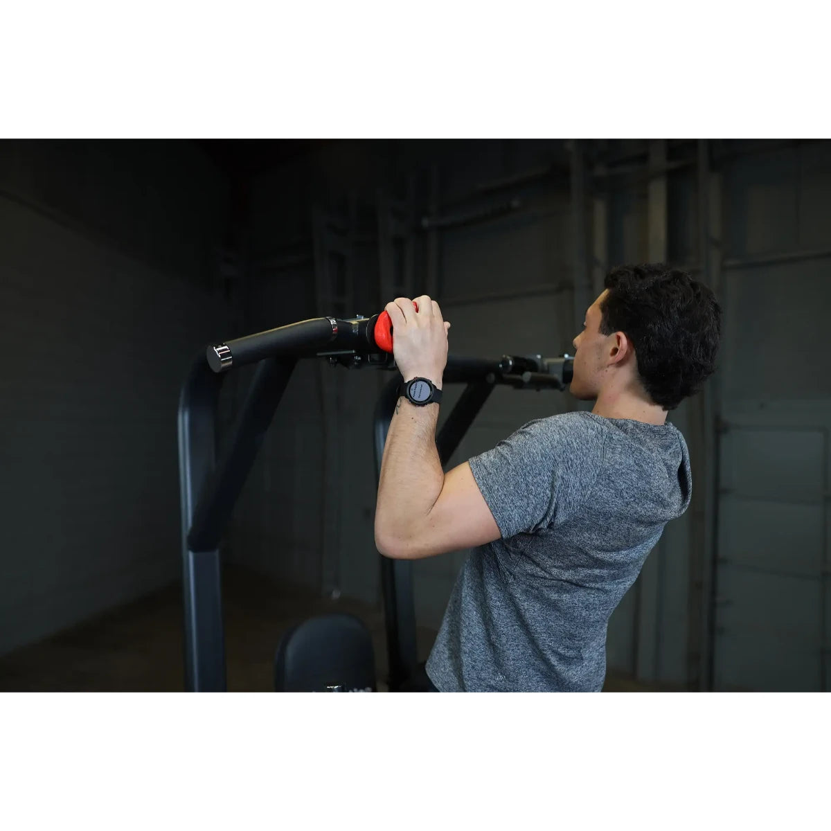 A person using the Body-Solid Pro Clubline Vertical Knee Raise SVKR1000, demonstrating an exercise with their hands gripping the handles.