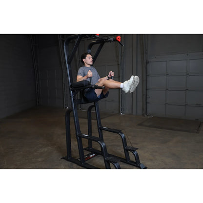 A person using the Body-Solid Pro Clubline Vertical Knee Raise SVKR1000 exercise machine, performing knee raises in a gym setting.