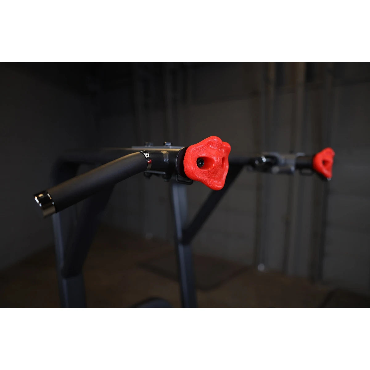 Close-up view of the Body-Solid Pro Clubline Vertical Knee Raise SVKR1000, featuring padded handles with red grips.