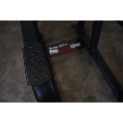 Close-up view of the Body-Solid Pro Clubline Vertical Knee Raise SVKR1000, showcasing the textured footpad and part of the equipment frame.
