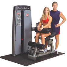 Body-Solid Pro Dual Ab & Back Machine DABBSF with a woman demonstrating its use and a man standing beside her, both in athletic attire.