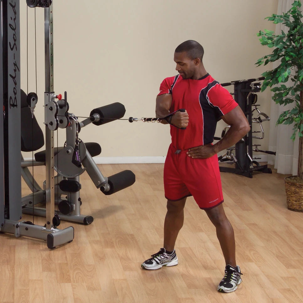 A fitness enthusiast using the Body-Solid Pro Dual Cable Column Machine DPCCSF for strength training, performing a cable exercise in a well-lit gym setting.