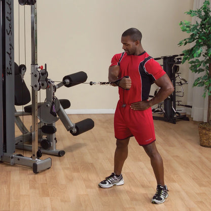 A fitness enthusiast using the Body-Solid Pro Dual Cable Column Machine DPCCSF for strength training, performing a cable exercise in a well-lit gym setting.