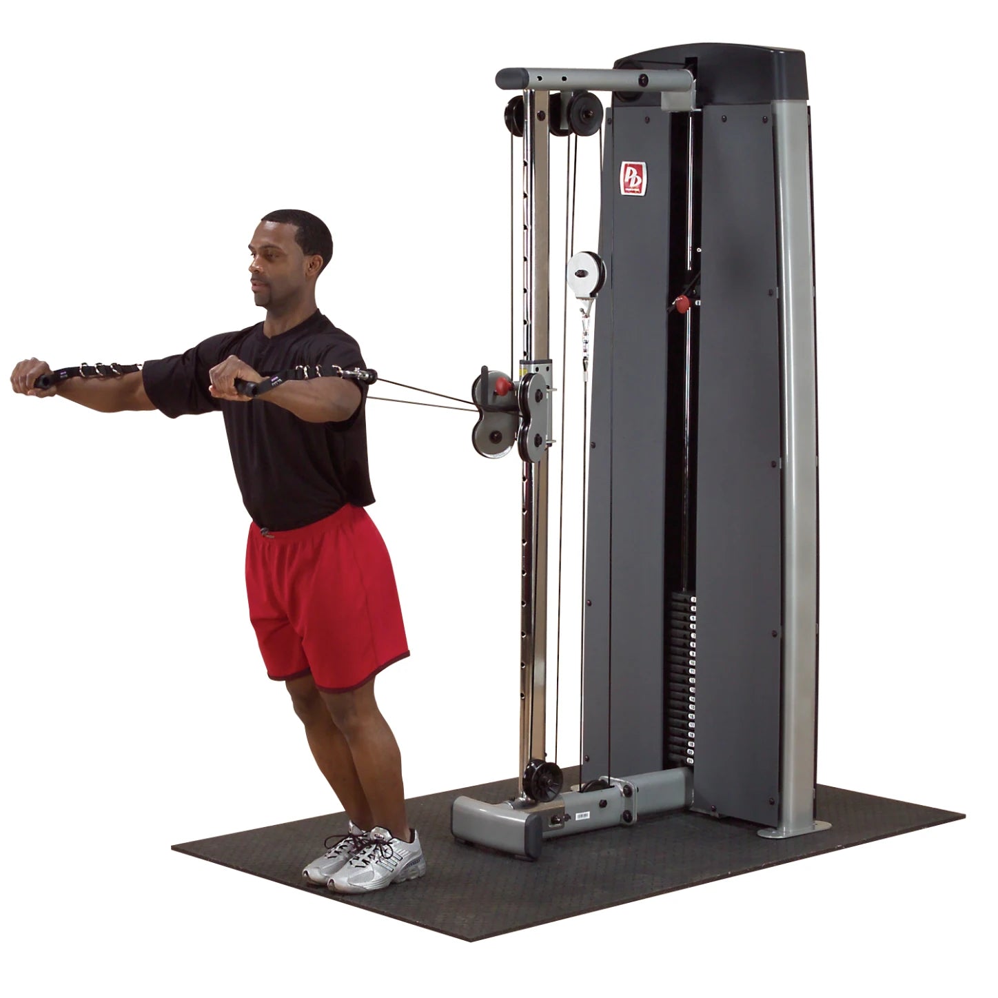 A man performing a cable exercise using the Body-Solid Pro Dual Cable Column Machine DPCCSF, with arms extended and cables in hand.