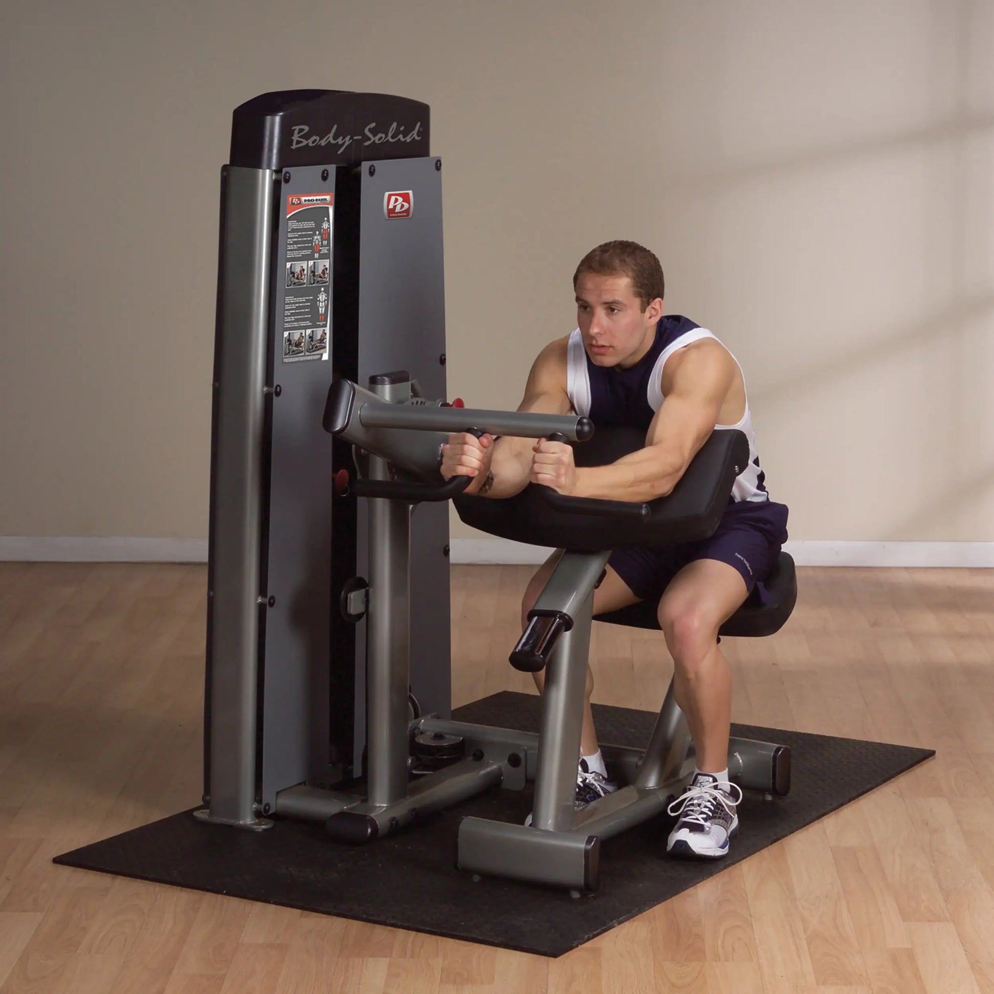 A man using the Body-Solid Pro Dual Bicep & Tricep Machine DBTCSF in a gym setting, focusing on bicep and tricep exercises.