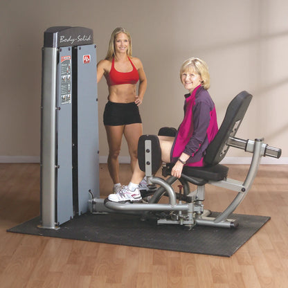 A fitness trainer standing next to a woman using the Body-Solid Pro Dual Inner & Outer Thigh Machine DIOTSF in a gym setting.
