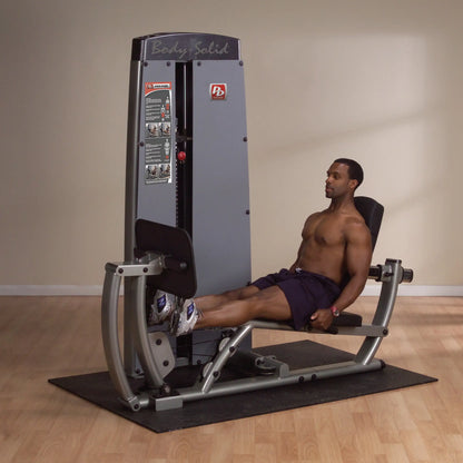 A man using the Body-Solid Pro Dual Leg & Calf Press Machine DCLPSF in a gym setting, performing a leg press exercise.