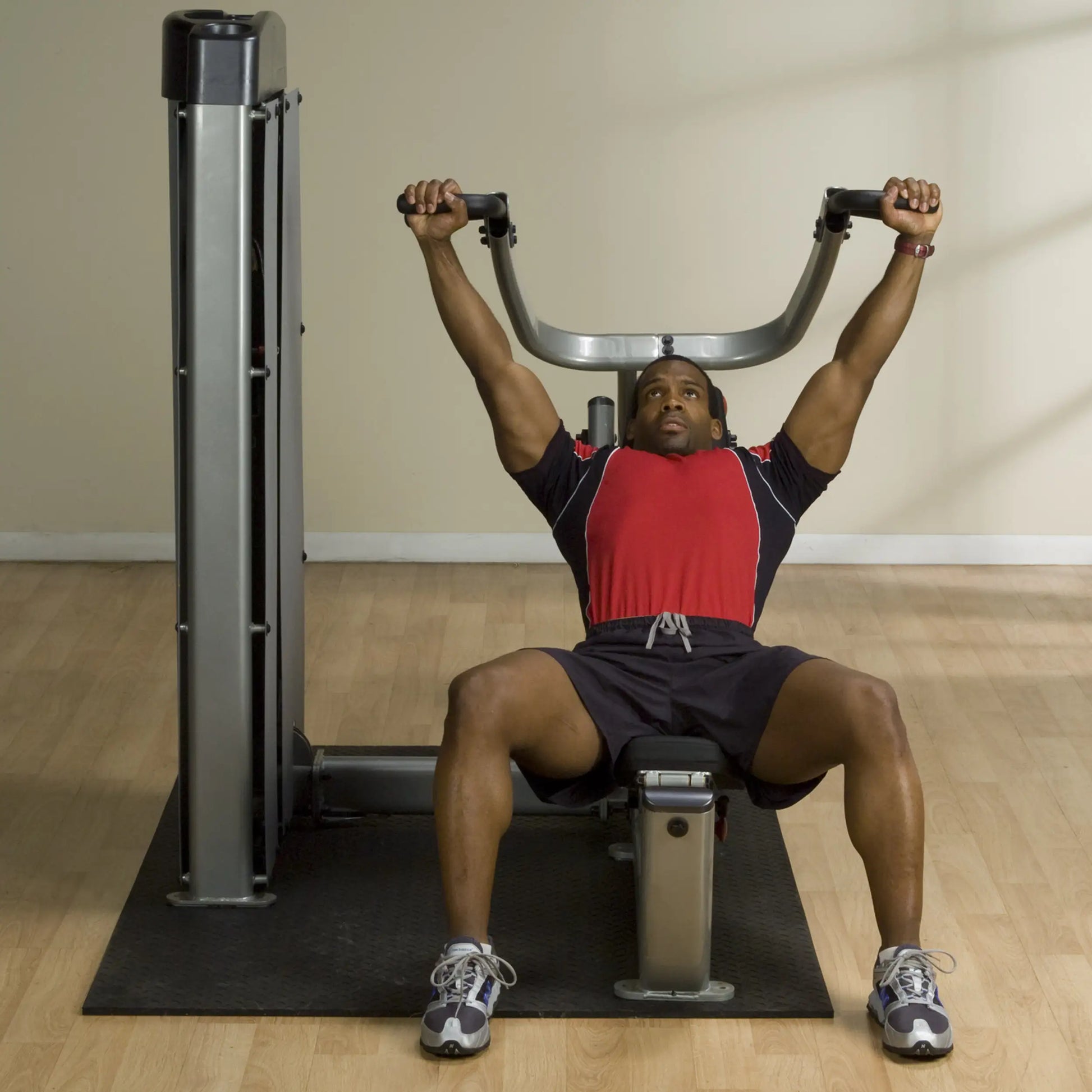 A person using the Body-Solid Pro Dual Multi-Press Machine DPRSSF, performing a pressing exercise while seated on the machine.