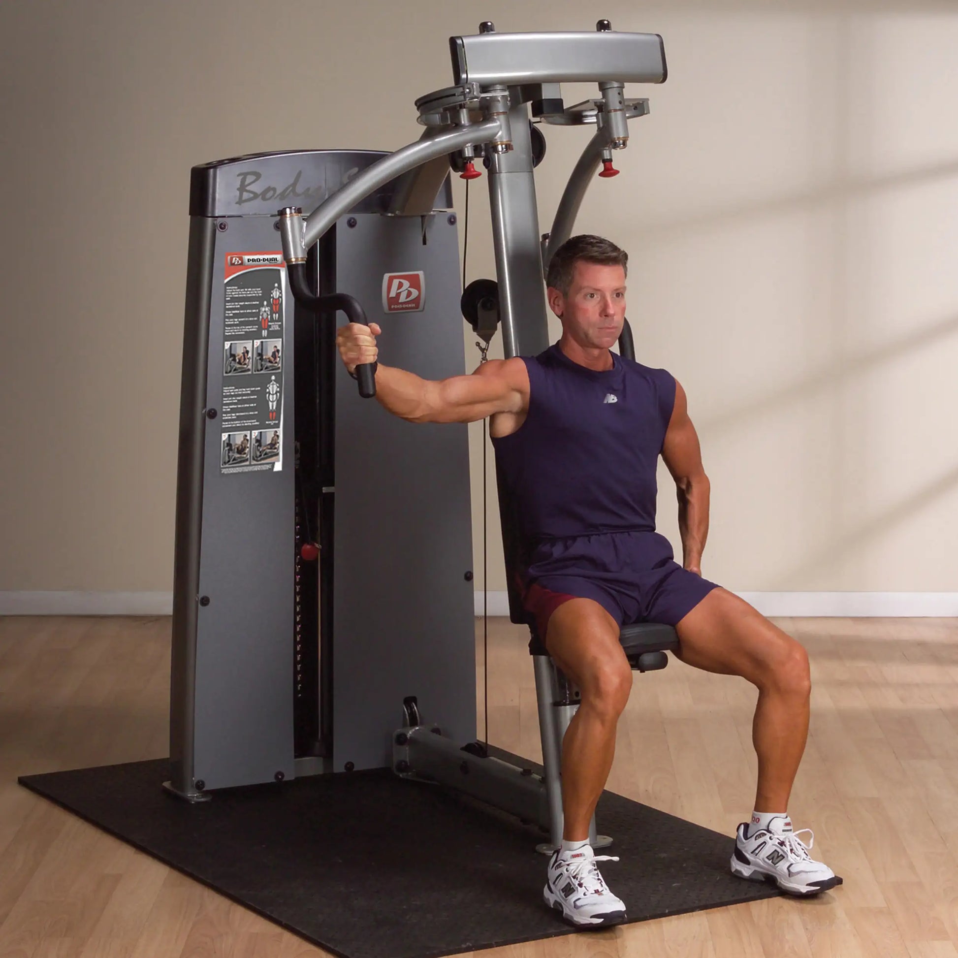 A person demonstrating the Body-Solid Pro Dual Pec & Rear Delt Machine DPECSF, performing a rear delt exercise while seated.